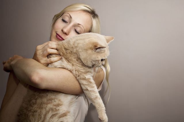 Женщина обнимает кота